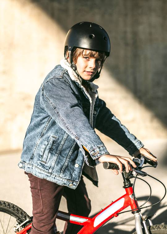 velo-vue-laterale-du-garcon-casque-securite-posant-son-velo.jpg